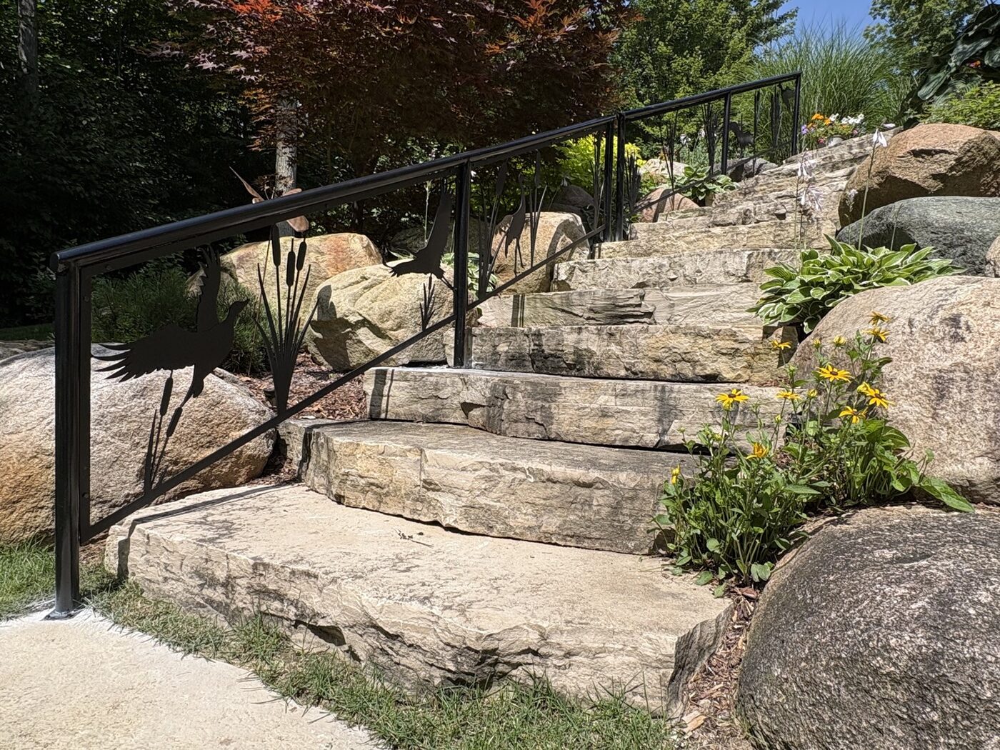 Wildlife garden stair handrail with laser-cut cranes and cattails